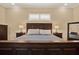 Comfortable main bedroom featuring a wood headboard, soft lighting, and neutral-toned walls at 15415 Mulholland Rd, Parrish, FL 34219