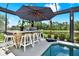 Outdoor stone bar with seating under an umbrella, overlooking pool and water views at 15415 Mulholland Rd, Parrish, FL 34219