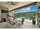 Screened patio with dining table and seating area overlooking the pool and lush landscaping at 15415 Mulholland Rd, Parrish, FL 34219