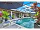 Luxurious screened-in pool area with plenty of seating, lush landscaping, and a great view at 15415 Mulholland Rd, Parrish, FL 34219