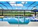Inviting pool with relaxing floating chairs and a picturesque water view, all enclosed in a screened lanai at 15415 Mulholland Rd, Parrish, FL 34219