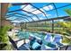 Relaxing screened pool area with comfortable lounge chairs overlooking a serene waterfront view at 15415 Mulholland Rd, Parrish, FL 34219