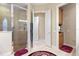 Bathroom featuring frameless shower, patterned rug, and an open doorway at 16608 Livingston Ave, Lutz, FL 33559