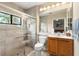 Bathroom with glass enclosed shower, tiled walls, and a wood vanity, offering a clean and modern design at 16608 Livingston Ave, Lutz, FL 33559
