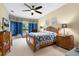 Comfortable bedroom featuring a ceiling fan, patterned bedding, and large windows at 16608 Livingston Ave, Lutz, FL 33559