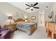 Warm bedroom boasting a ceiling fan, patterned bedding, and large windows at 16608 Livingston Ave, Lutz, FL 33559