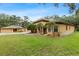 Charming home with mature landscaping and a well-manicured lawn creating a welcoming curb appeal at 16608 Livingston Ave, Lutz, FL 33559
