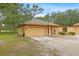 Single-story home with a three-car garage, lush landscaping, and an inviting curb appeal at 16608 Livingston Ave, Lutz, FL 33559