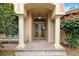 Grand front entrance featuring elegant columns, a covered porch, and a well-manicured garden at 16608 Livingston Ave, Lutz, FL 33559