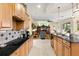 Well-lit kitchen features black countertops, wood cabinets, and stainless steel appliances at 16608 Livingston Ave, Lutz, FL 33559