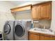Functional laundry room with a utility sink, washer, dryer, and storage cabinets at 16608 Livingston Ave, Lutz, FL 33559