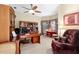 Inviting home office featuring a ceiling fan, comfortable seating, and a large desk with built-in shelving at 16608 Livingston Ave, Lutz, FL 33559