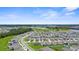 Expansive aerial view of a vibrant community with well-maintained homes and lush green spaces under a clear blue sky at 17005 Avon Dive Ln, Wimauma, FL 33598