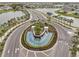 Aerial view of a meticulously planned community entrance with lush landscaping and a water feature at 17005 Avon Dive Ln, Wimauma, FL 33598
