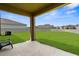 Spacious backyard with a well-maintained lawn, partial view from the covered patio, and a perimeter fence at 17005 Avon Dive Ln, Wimauma, FL 33598
