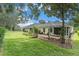 Expansive backyard with green lawn, mature trees, and multiple covered patios at 17910 Timber View St, Tampa, FL 33647