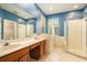 Bathroom with double sinks, soaking tub, walk-in shower and tile flooring at 17910 Timber View St, Tampa, FL 33647