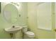 Powder room featuring a pedestal sink, toilet, and a window that offers natural light at 17910 Timber View St, Tampa, FL 33647