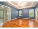 The main bedroom features three windows, beautiful wood flooring, and sliding glass door entry to the backyard at 17910 Timber View St, Tampa, FL 33647