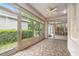 Sunroom with tiled floor and many windows showcasing an outdoor area with lush greenery at 17910 Timber View St, Tampa, FL 33647