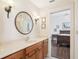 Bathroom features a marble countertop vanity, a decorative round mirror, and access to the adjacent bedroom at 1803 143Rd E Ct, Bradenton, FL 34212