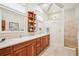 Spacious bathroom with double vanity, wood cabinets, and tiled shower at 1803 143Rd E Ct, Bradenton, FL 34212