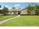 Charming home with a stone facade, manicured lawn, and a brick walkway leading to the front entrance at 1803 143Rd E Ct, Bradenton, FL 34212