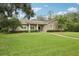 Inviting home showcasing a lush green lawn, mature trees, and a classic design with stone accents at 1803 143Rd E Ct, Bradenton, FL 34212