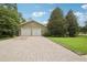 Stone-accented two-car garage with a brick driveway and manicured lawn, providing ample parking and curb appeal at 1803 143Rd E Ct, Bradenton, FL 34212