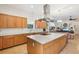 Open-concept kitchen with a central island, modern range hood, and seamless transition to the living area at 1803 143Rd E Ct, Bradenton, FL 34212