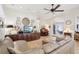 Bright living room with tile flooring, piano, ceiling fan, and comfortable leather sofa at 1803 143Rd E Ct, Bradenton, FL 34212