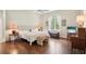 Bright main bedroom features hardwood floors, soft lighting, and a window with beautiful views at 1803 143Rd E Ct, Bradenton, FL 34212