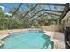 Beautifully designed screened-in pool with a tile border and lush landscaping at 1803 143Rd E Ct, Bradenton, FL 34212