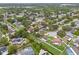 An aerial shot showcases a well-maintained neighborhood with lush green trees and diverse housing options at 1909 Dover Ct, Oldsmar, FL 34677