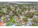 Overhead view of a community with pools, green spaces, and diverse home styles near a lake at 1909 Dover Ct, Oldsmar, FL 34677
