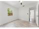 Bright bedroom with a ceiling fan, light-colored wood-look flooring and a large window overlooking a lush landscape at 1909 Dover Ct, Oldsmar, FL 34677