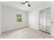 Light-filled bedroom featuring wood-look floors, a ceiling fan, and mirrored closet doors at 1909 Dover Ct, Oldsmar, FL 34677
