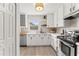 Contemporary kitchen features white cabinets, butcher block and stainless steel appliances at 1909 Dover Ct, Oldsmar, FL 34677
