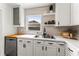 Well-lit kitchen boasts white cabinets, floating shelves, and stainless steel appliances at 1909 Dover Ct, Oldsmar, FL 34677
