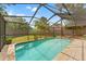 A sparkling in-ground pool surrounded by brick pavers in a screened-in backyard at 1909 Dover Ct, Oldsmar, FL 34677