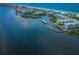Breathtaking aerial view showcasing a waterfront condo complex, docks, lush greenery, and the sparkling ocean coastline at 19531 Gulf Blvd # 306, Indian Shores, FL 33785