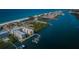 An aerial view showcasing buildings with a dock and boats along the shore and the nearby sandy beach at 19531 Gulf Blvd # 306, Indian Shores, FL 33785