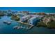 Stunning aerial view of waterfront condos, docks, and boats with beach in the distance at 19531 Gulf Blvd # 306, Indian Shores, FL 33785