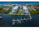 Aerial view showcases complex with beautiful pool, lush landscaping, and boat docks at 19531 Gulf Blvd # 306, Indian Shores, FL 33785