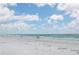 Scenic beach view with fluffy clouds, azure skies, fine white sand, and a gentle ocean at 19531 Gulf Blvd # 306, Indian Shores, FL 33785