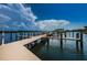 Scenic boat dock featuring wooden pilings and decking on the water under a bright blue, partly cloudy sky at 19531 Gulf Blvd # 306, Indian Shores, FL 33785