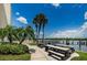 Scenic community area with picnic tables, grills, palm trees, and a serene waterfront view at 19531 Gulf Blvd # 306, Indian Shores, FL 33785