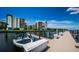 Community boat dock and boat lift featuring multiple docking areas and boating access with waterfront views of the building at 19531 Gulf Blvd # 306, Indian Shores, FL 33785
