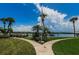 Beautiful community view with manicured lawn, sidewalks, palm trees, picnic tables, and access to the Intercoastal Waterway at 19531 Gulf Blvd # 306, Indian Shores, FL 33785