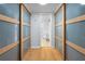 Hallway view leading to a bathroom, framed by closet doors and complemented by hardwood flooring at 19531 Gulf Blvd # 306, Indian Shores, FL 33785